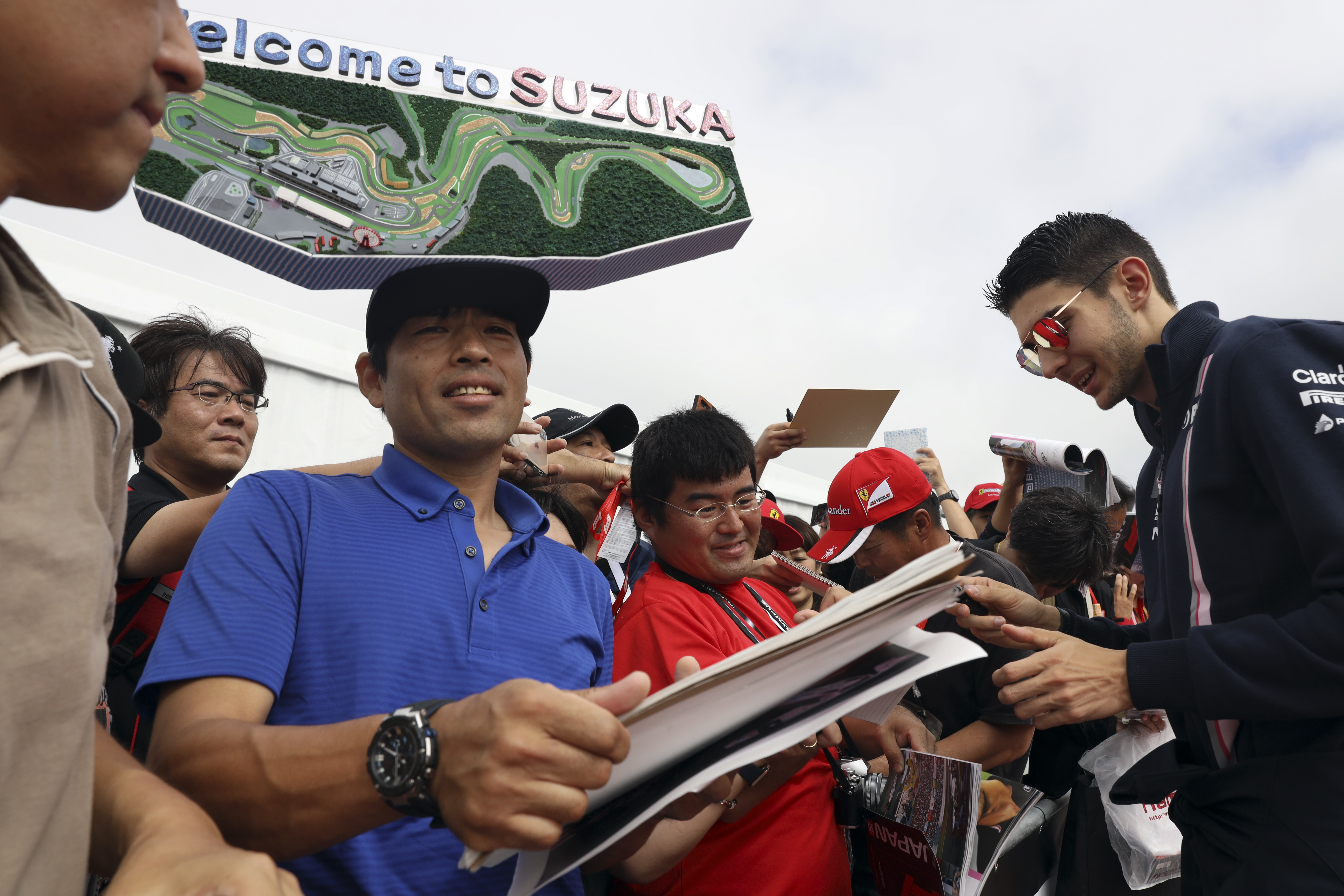 Force India driver Esteban Ocon of France signs autographs as he arrives at the Suzuka Circuit ahead of the Japanese Formula One Grand Prix in Suzuka, central Japan - AP