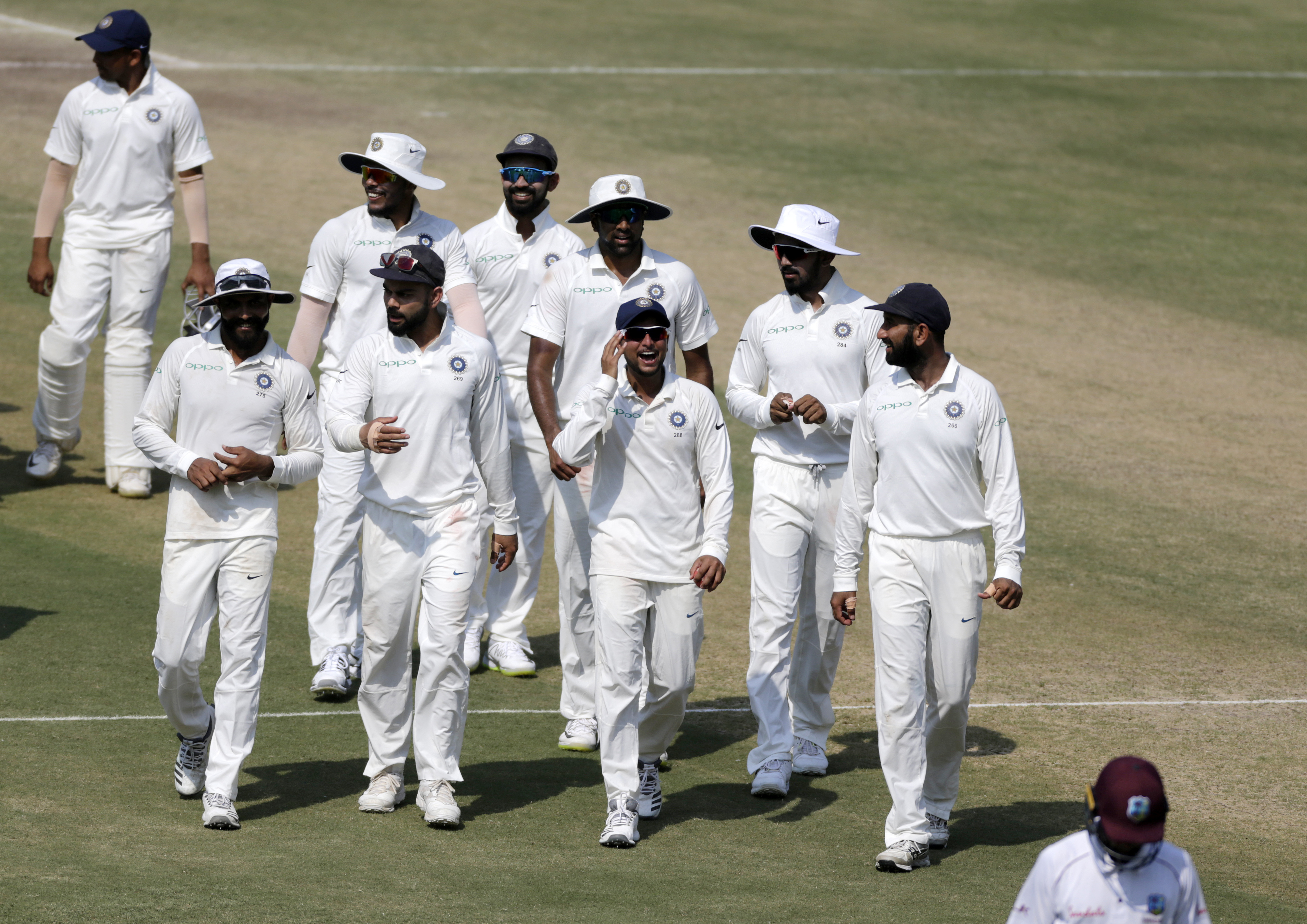 Indian cricketers leave the field after their victory over West Indies in the first cricket test match in Rajkot - AP