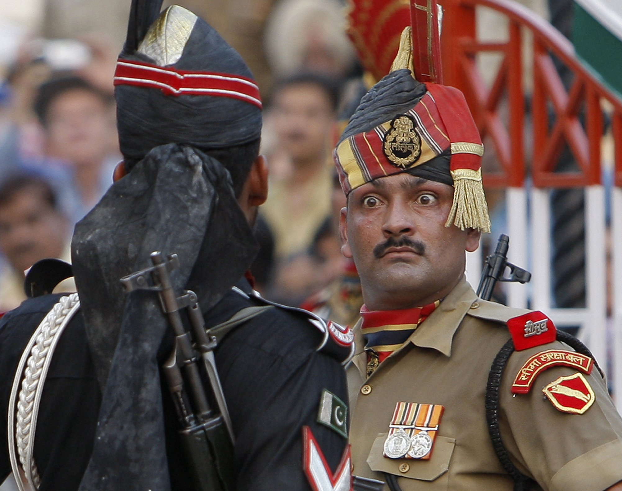 Indian Border Security Force soldier, right, and a Pakistani Rangers soldier face one another at a daily closing ceremony at the Wagah border post near Lahore - AP