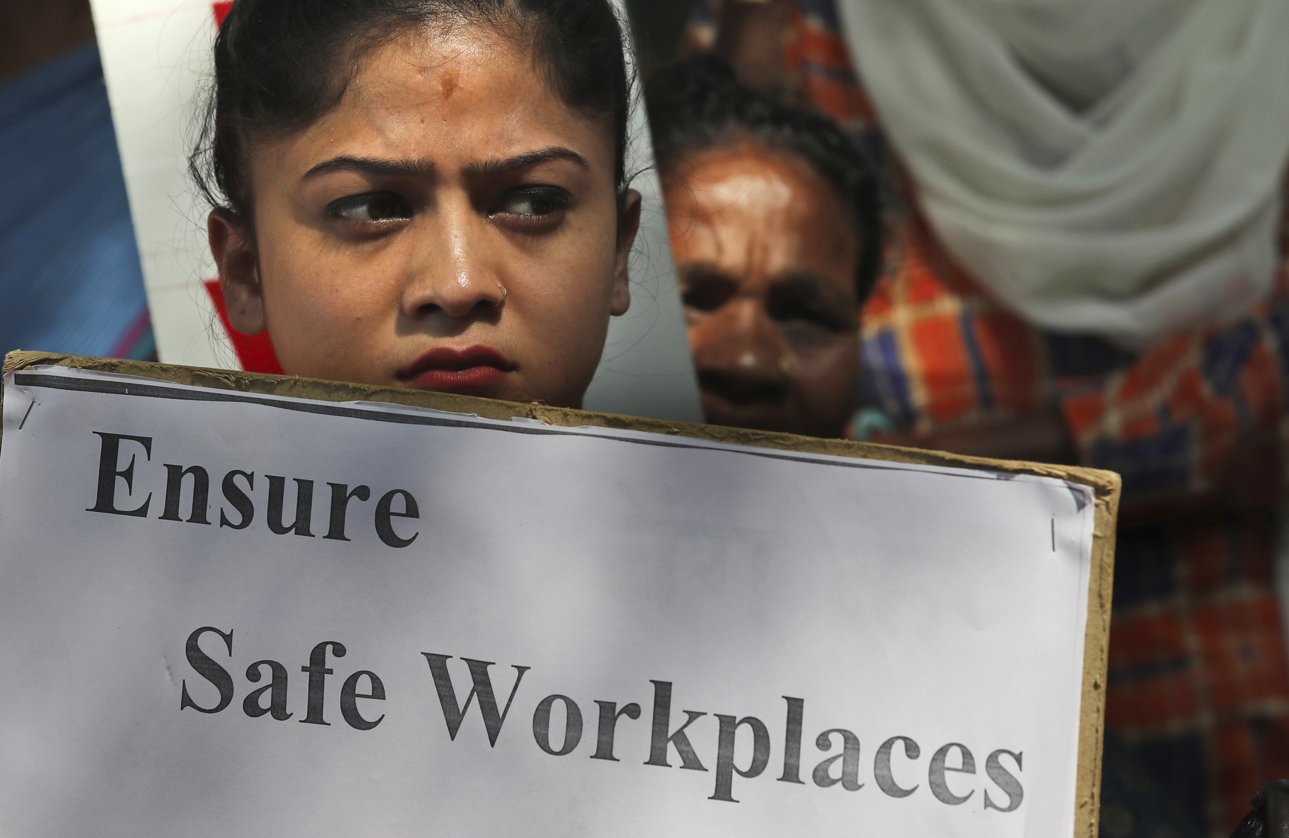 An Indian woman holds a banner during a protest against sexual harassment in the workplace in New Delhi - AP