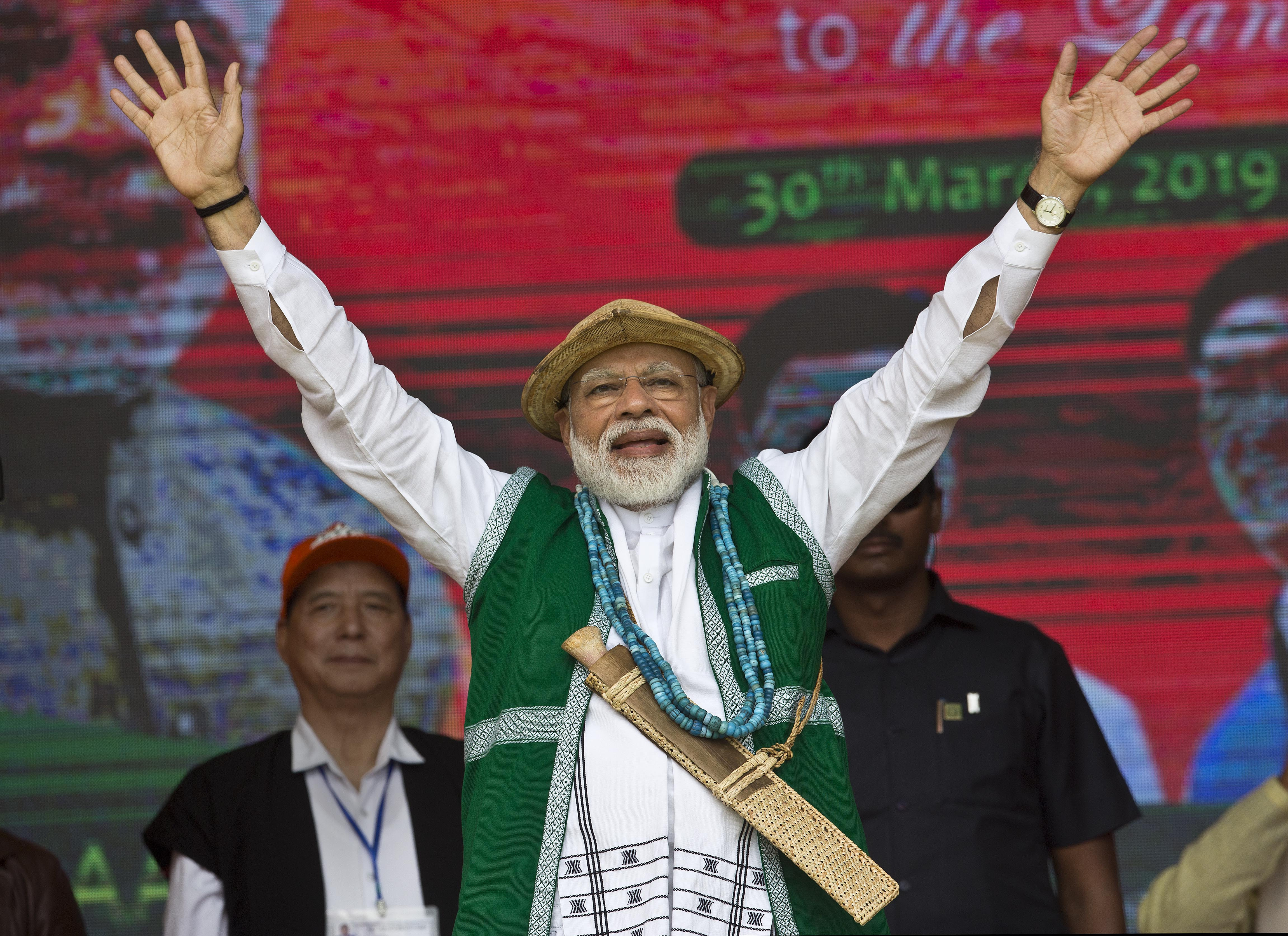 Prime Minister Narendra Modi in traditional tribal attire waves to supporters of his Bharatiya Janata Party (BJP) at an election campaign rally in Along, Arunachal Pradesh, India - PTI