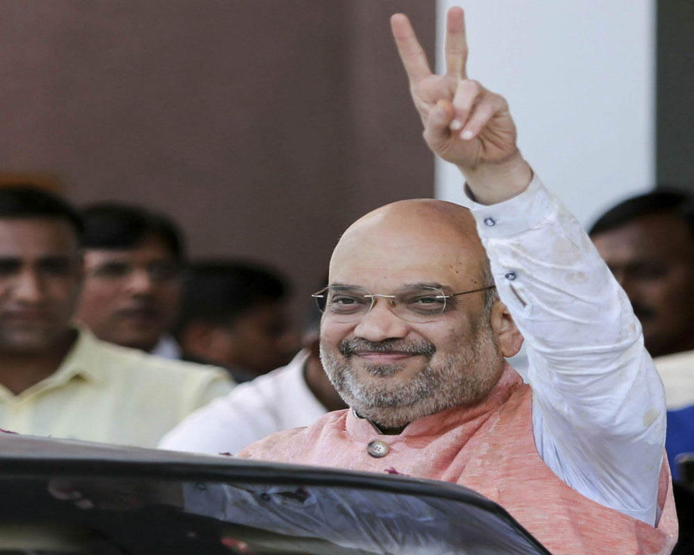 BJP National President Amit Shah shows victory sign after filing his nomination for the upcoming Lok Sabha elections, at collectors office in Gandhinagar - PTI