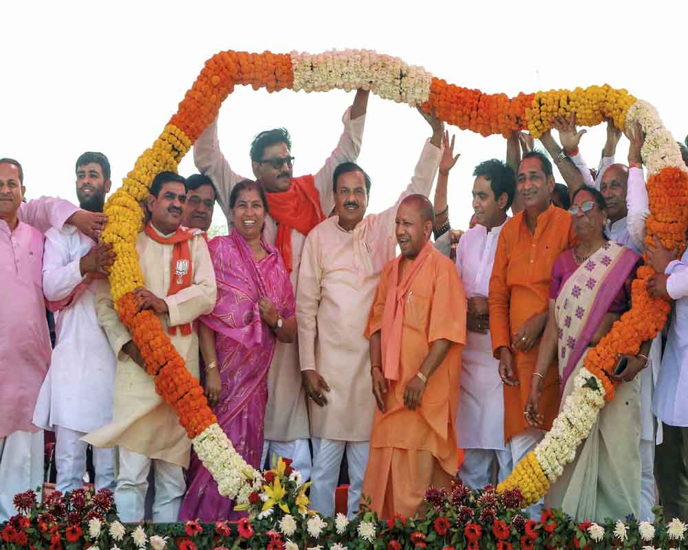 Uttar Pradesh Chief Minister Yogi Adityanath being garlanded at an election rally in support of Union Minister and BJP candidate Mahesh Sharma, ahead of the Lok Sabha elections - PTI