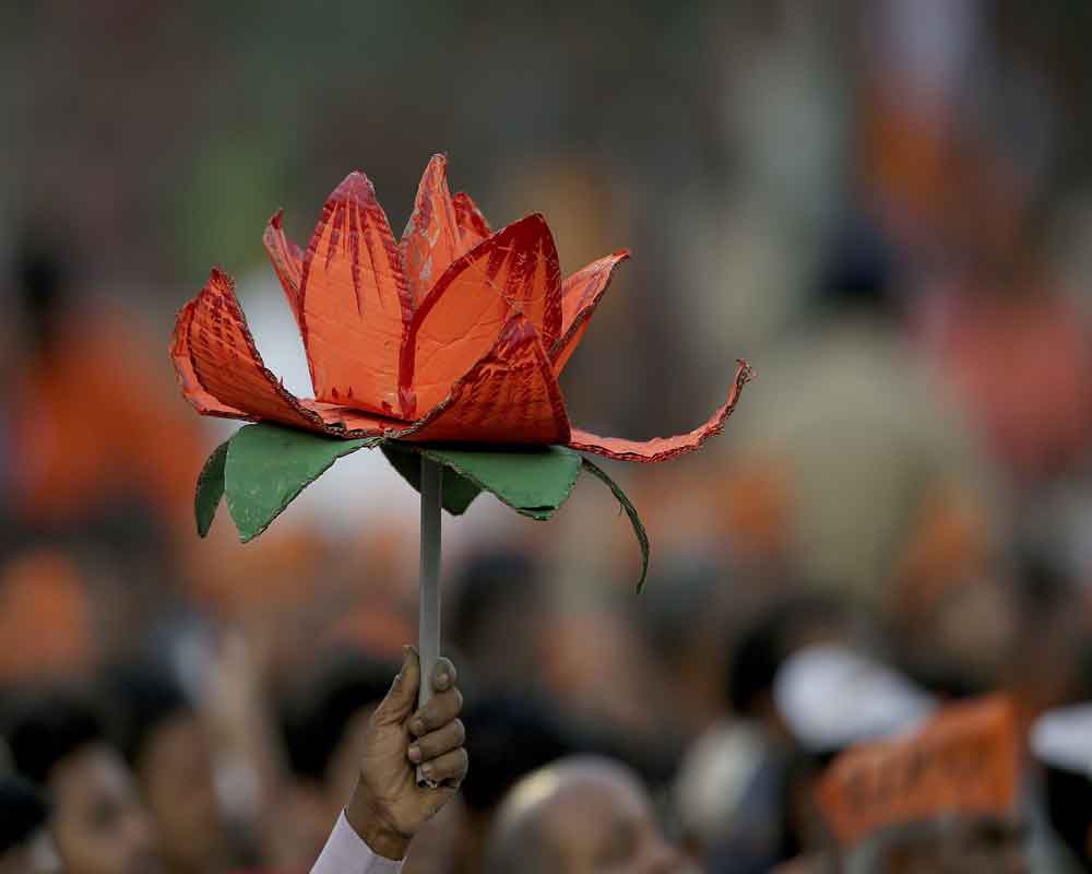 India's ruling Bharatiya Janata Party (BJP) supporter holds party symbol during an election campaign rally in Hyderabad - AP