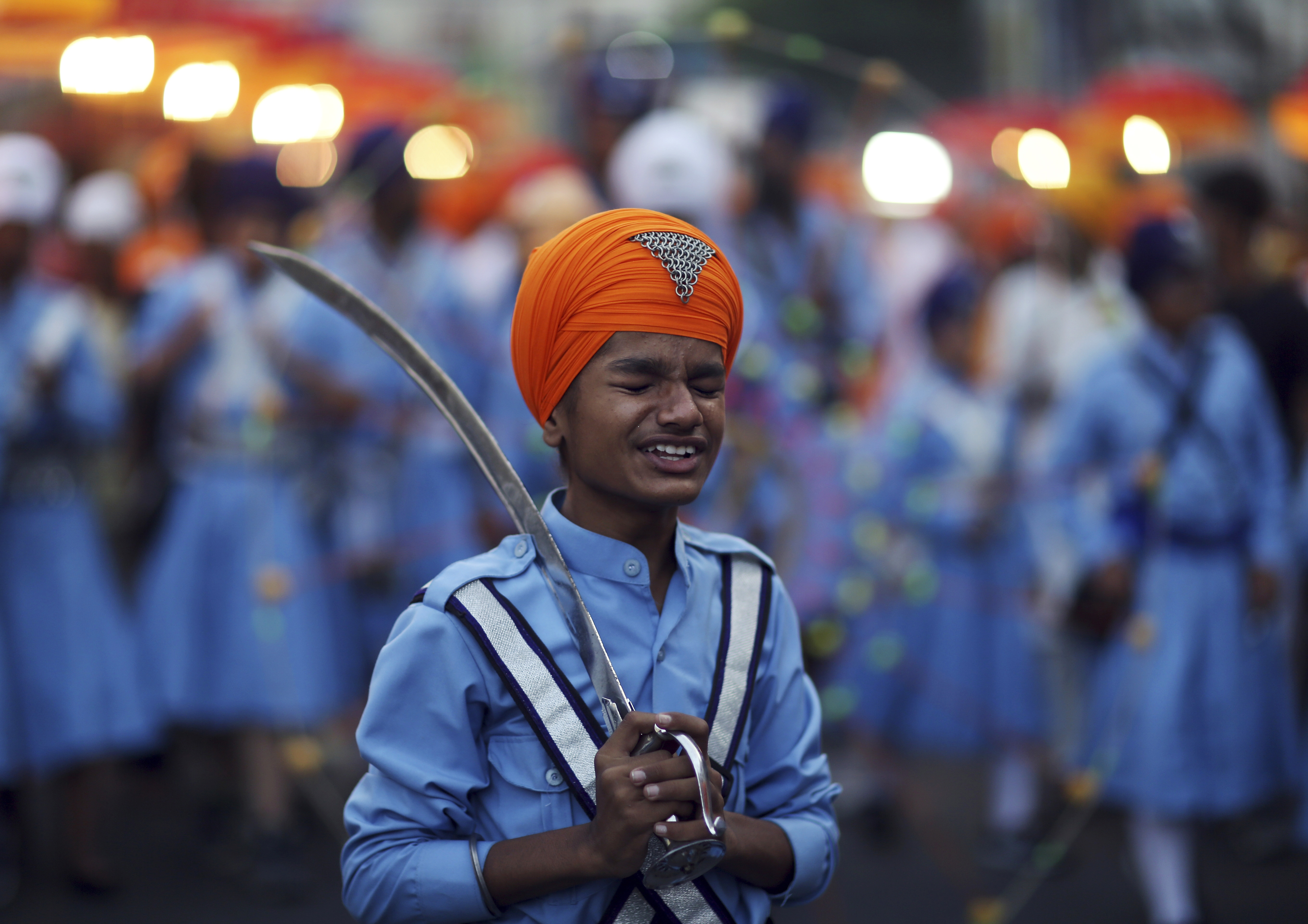 A Sikh boy reacts to a jovial comment from another as he prepares to display his martial art skills during a religious procession ahead of the birth anniversary of the first Sikh guru, Guru Nanak, in Hyderabad - AP