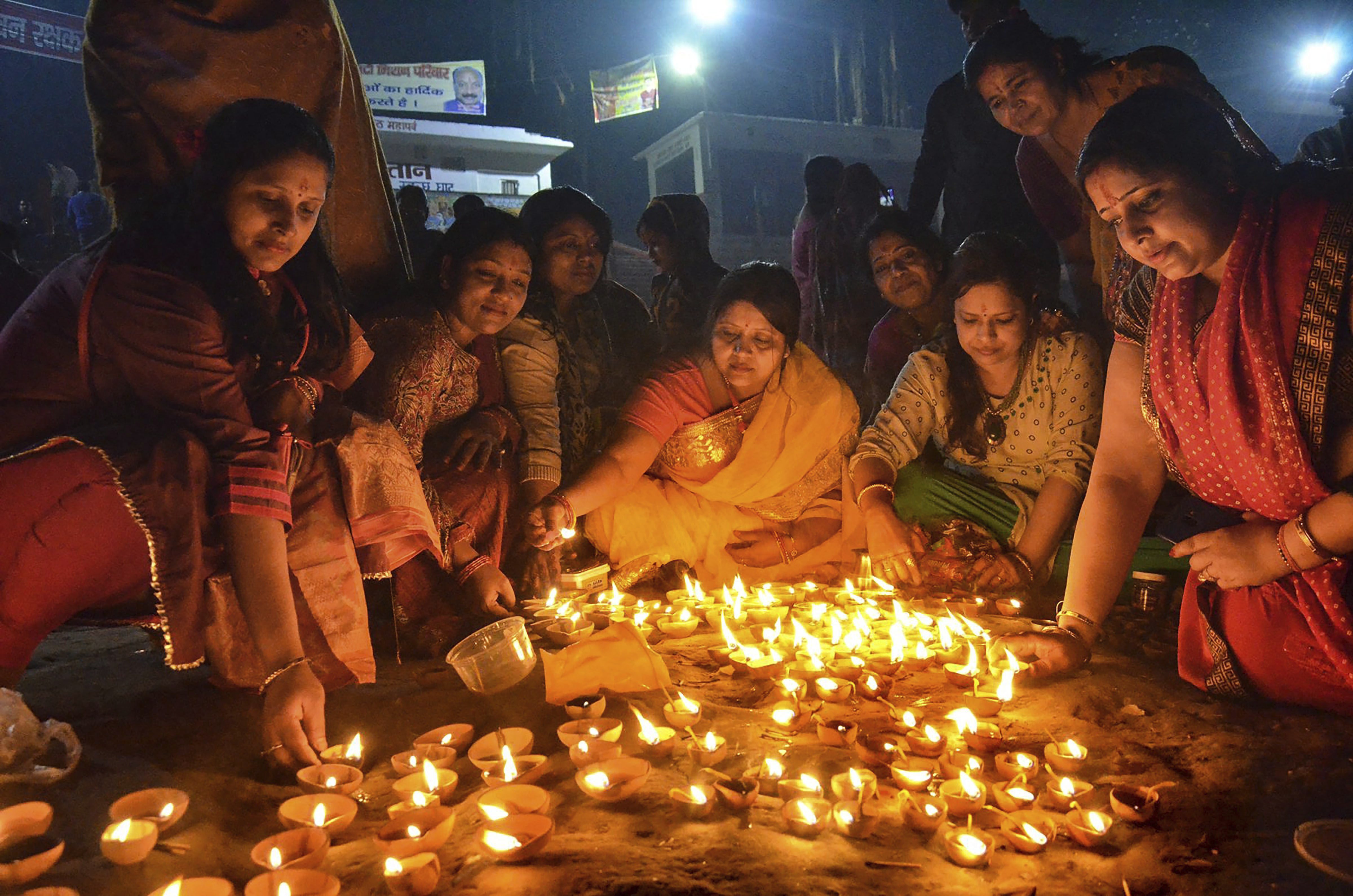 Hindu women light lamps at the bank of Budhi Gandak river, to mark Dev Deepawali festival, in Muzaffarpur - PTI