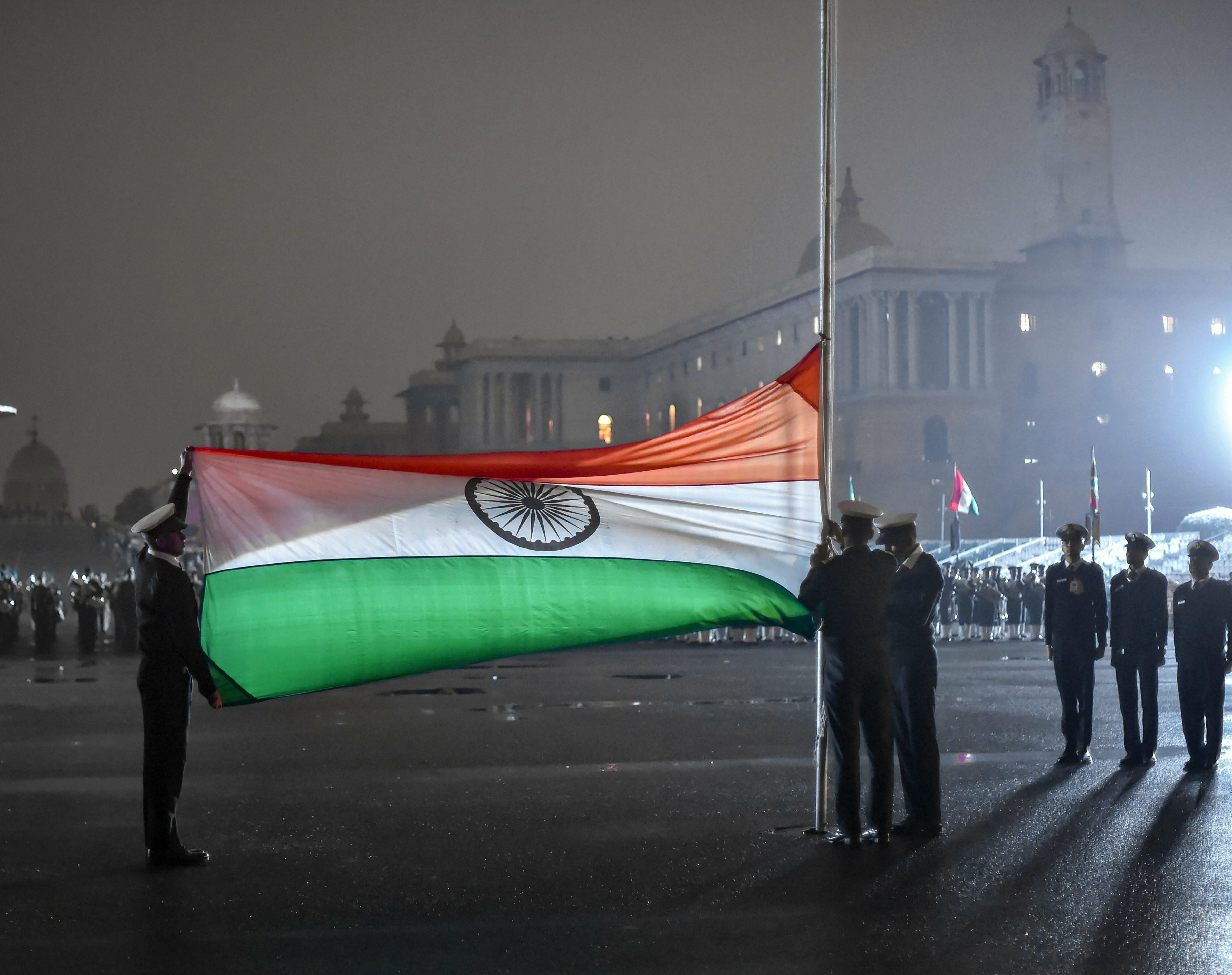 Soldiers fold-up the Tricolour during rehearsal for the Beating Retreat ceremony, in New Delhi - PTI