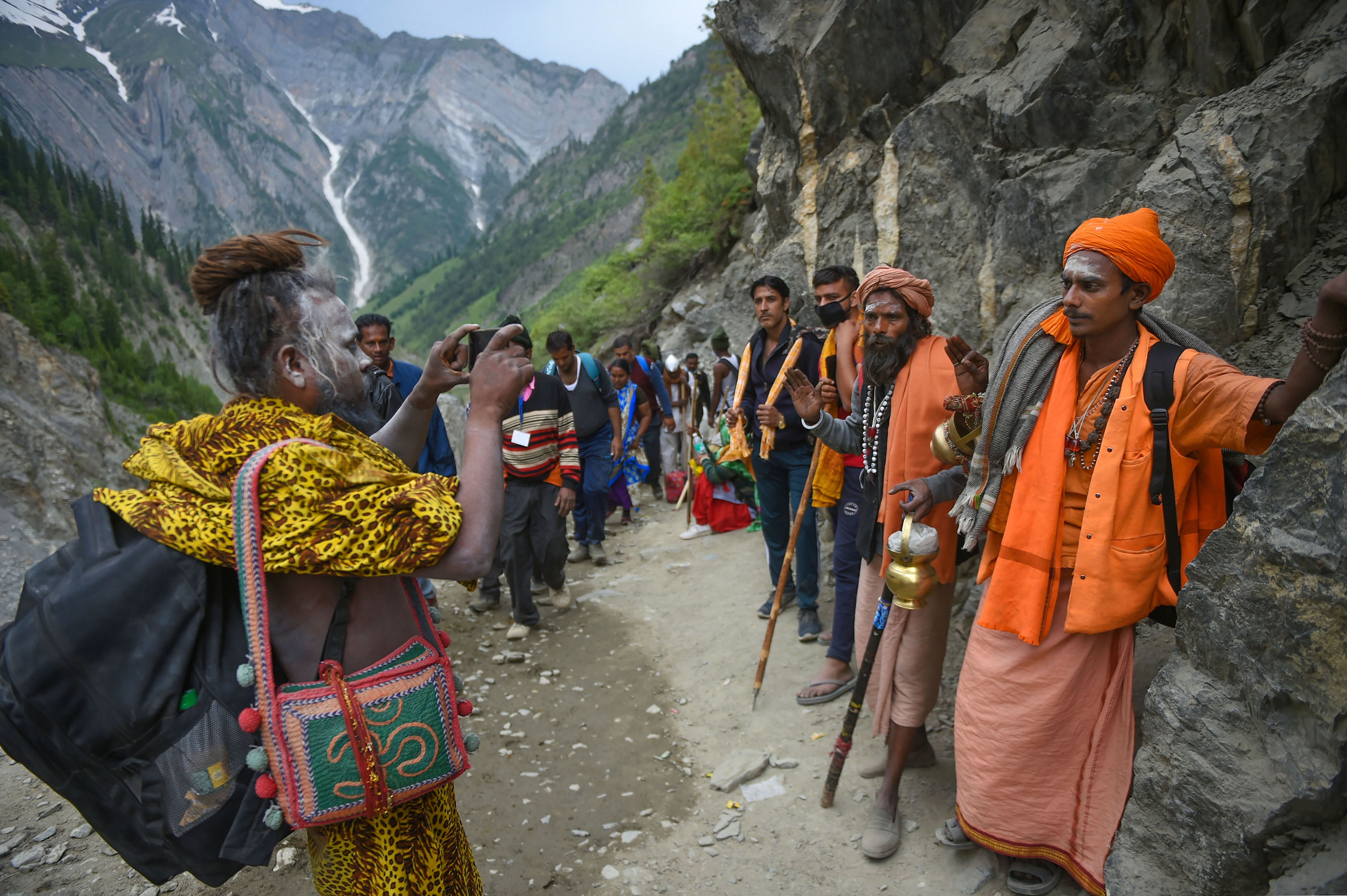 Sadhus take their pictures with mobile phones during their pilgrimage to the holy cave shrine of Amarnath, in Baltal - PTI