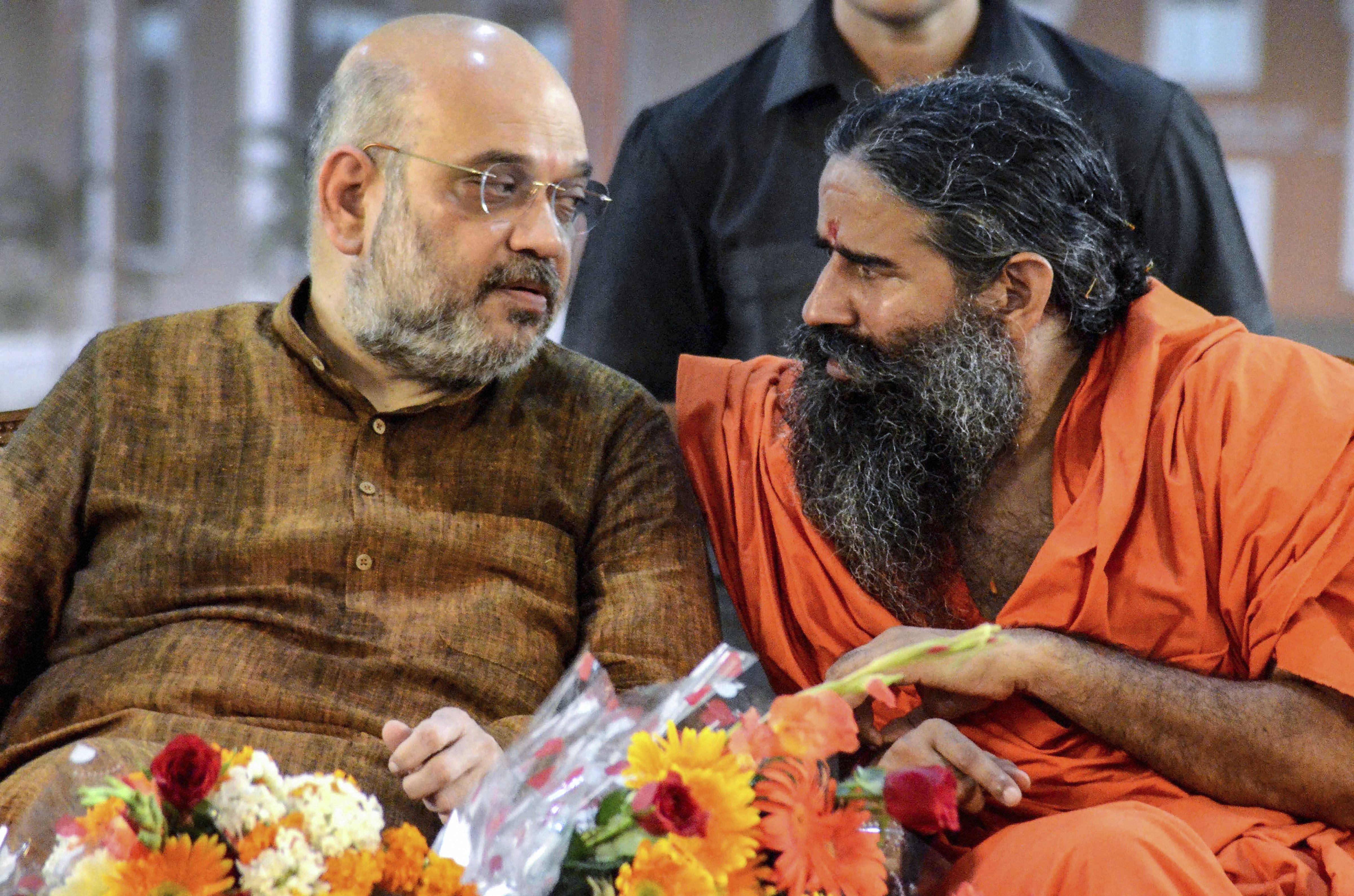 BJP President Amit Shah speaks with yoga guru Baba Ramdev during the inauguration of newly-built second campus of Acharyakulum at Patanjali Yog Peeth, in Haridwar - PTI