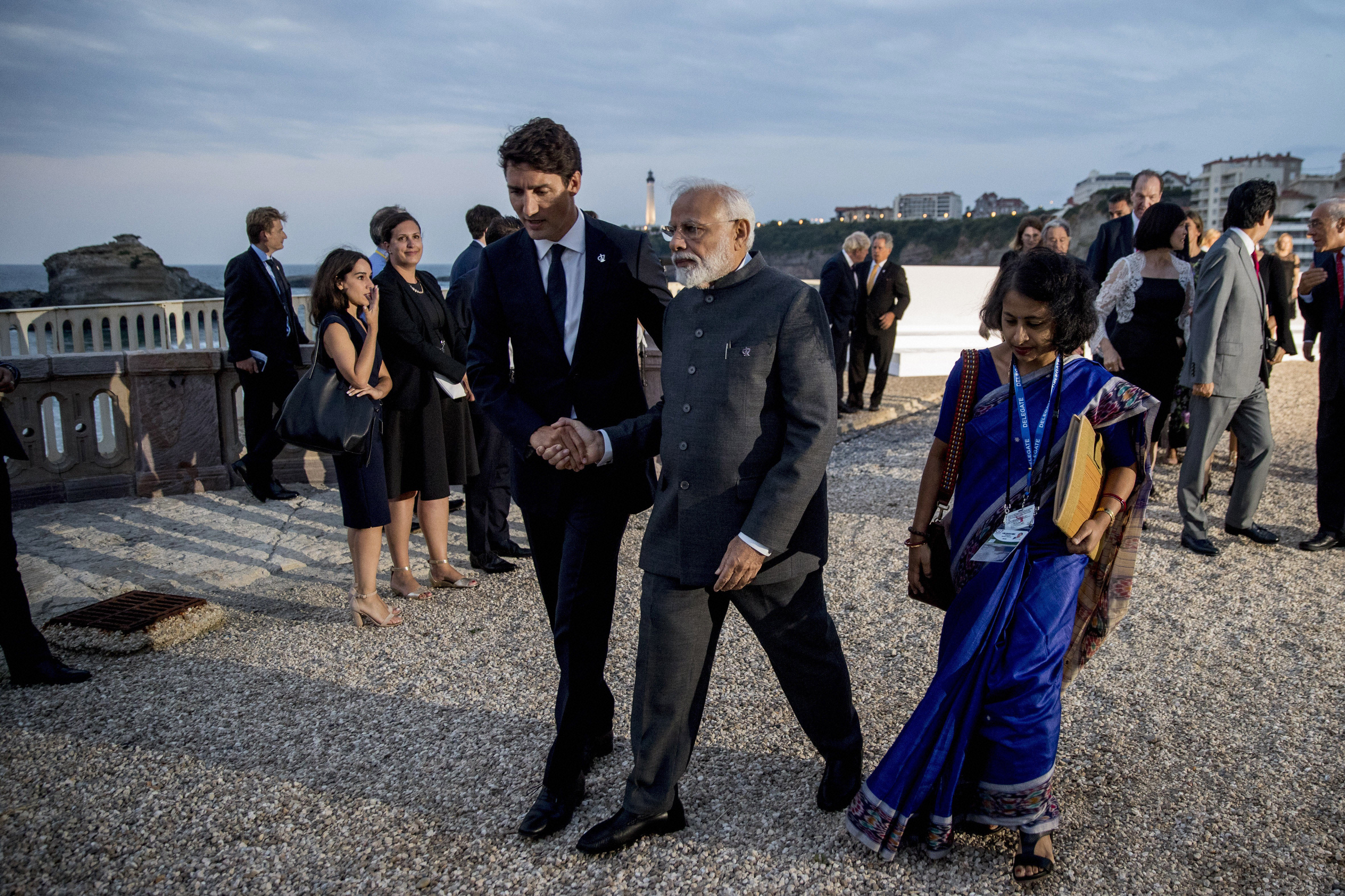 Canadian Prime Minister Justin Trudeau, center left, and Indian Prime Minister Narendra Modi, center right, walk together following the G-7 family photo with guests at G-7 summit at the Hotel du Palais in Biarritz - PTI