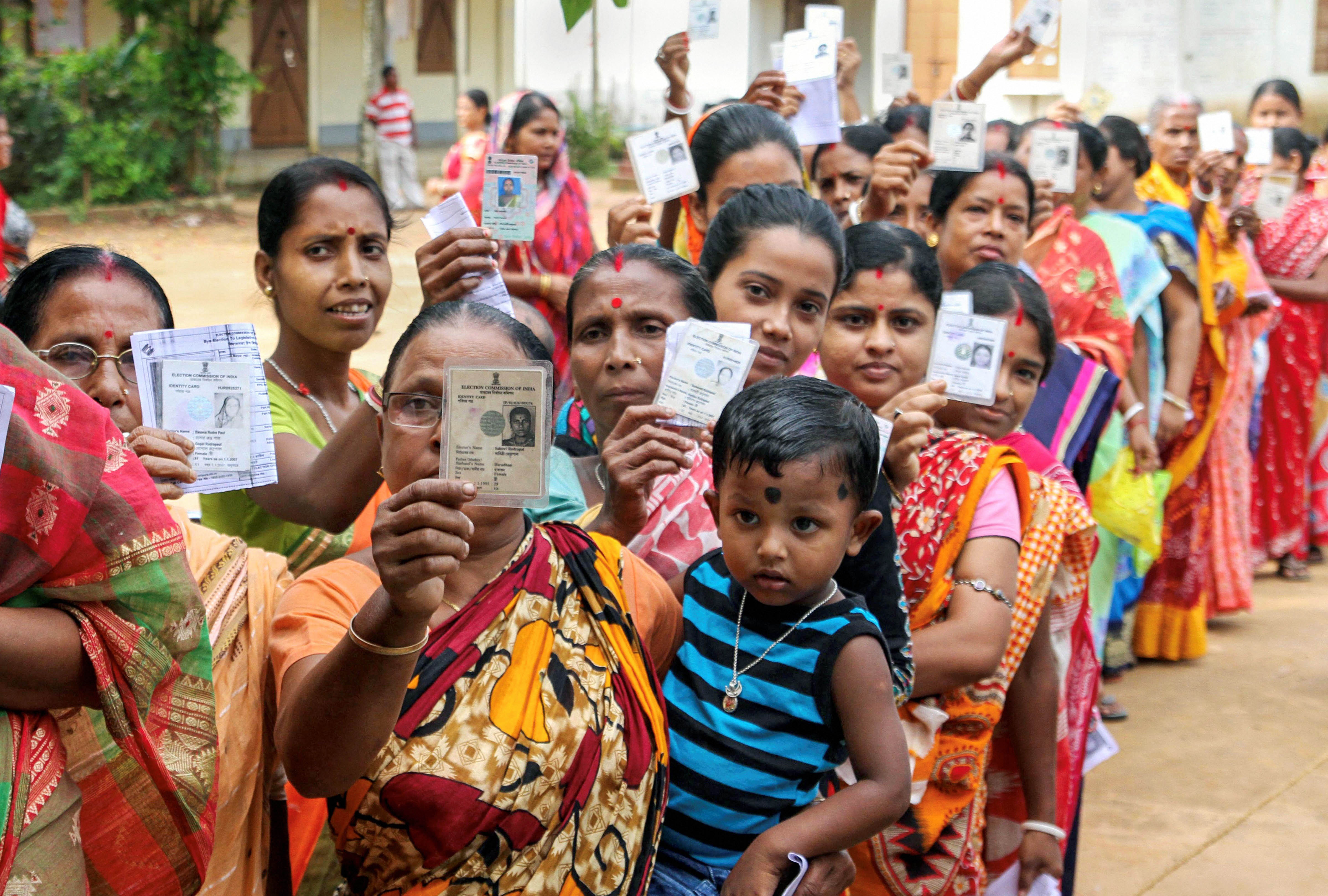 Voters wait in queues to cast their votes at a polling station during the Badharghat Assembly constituency by-elections at a village, on the outskirts of Agartala - PTI